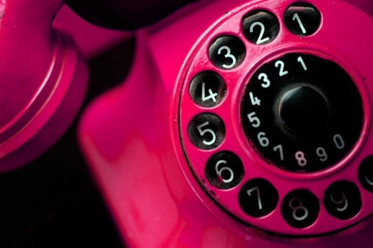Téléphone vintage rose avec cadran rotatif pour communication rétro.